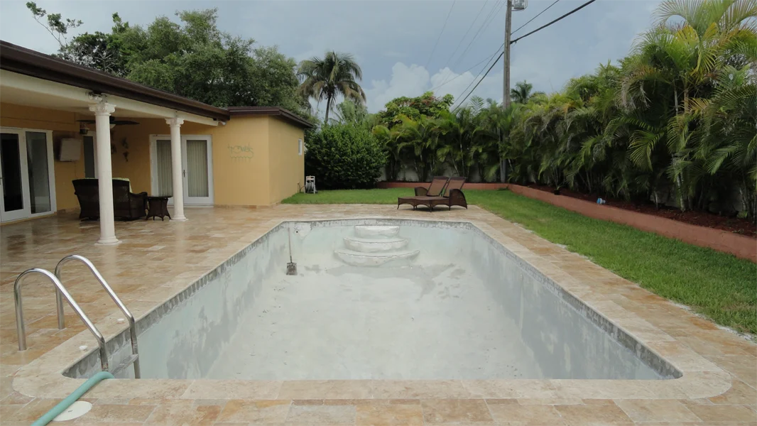 Old stained pool plaster before resurfacing in Miami FL