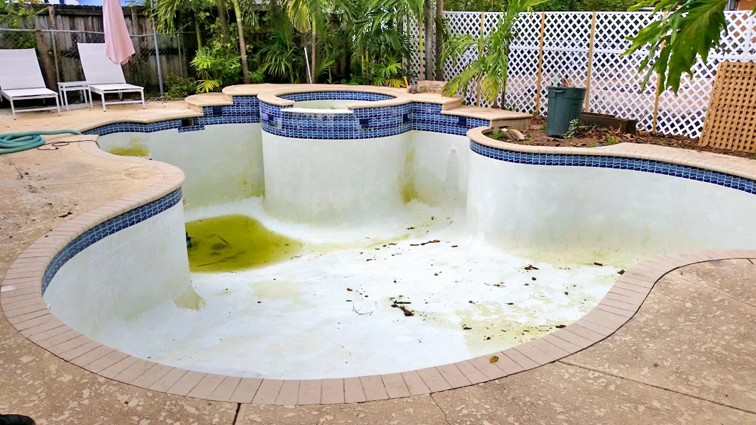 Old stained pool plaster before resurfacing in Miami FL
