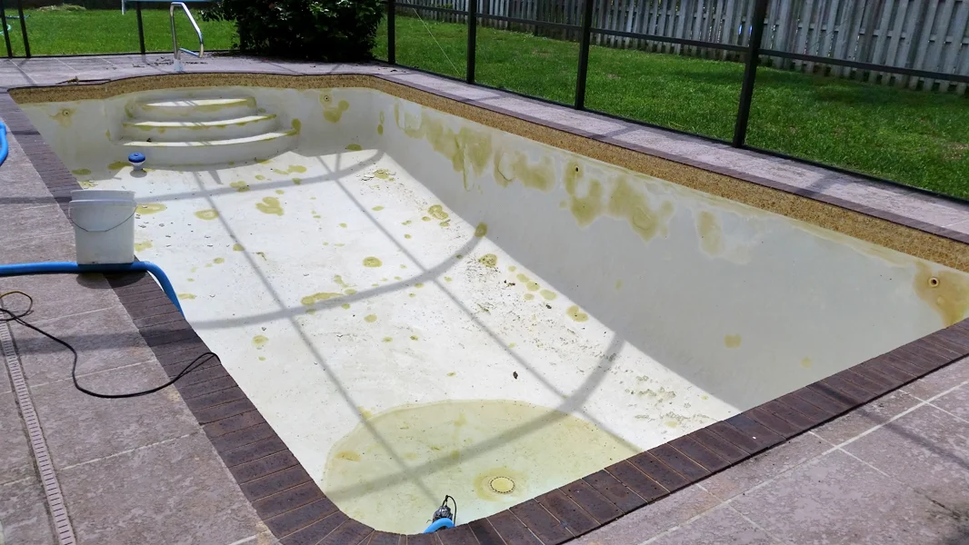 Old stained pool plaster before resurfacing in Miami FL
