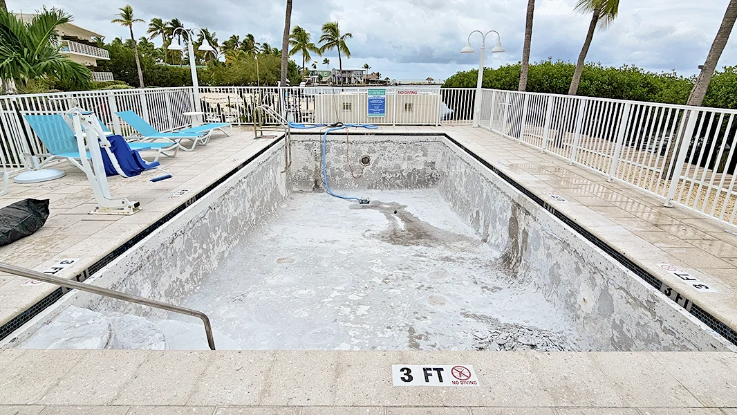 Old stained pool plaster before resurfacing in Miami FL